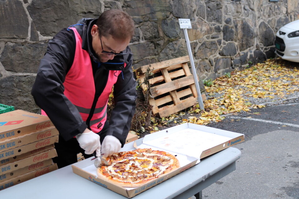 Peer Lochting jobber som frivillig på Fattighuset og deler ut pizza til de som står i matkø. Foto Camilla Skjær Brugrand